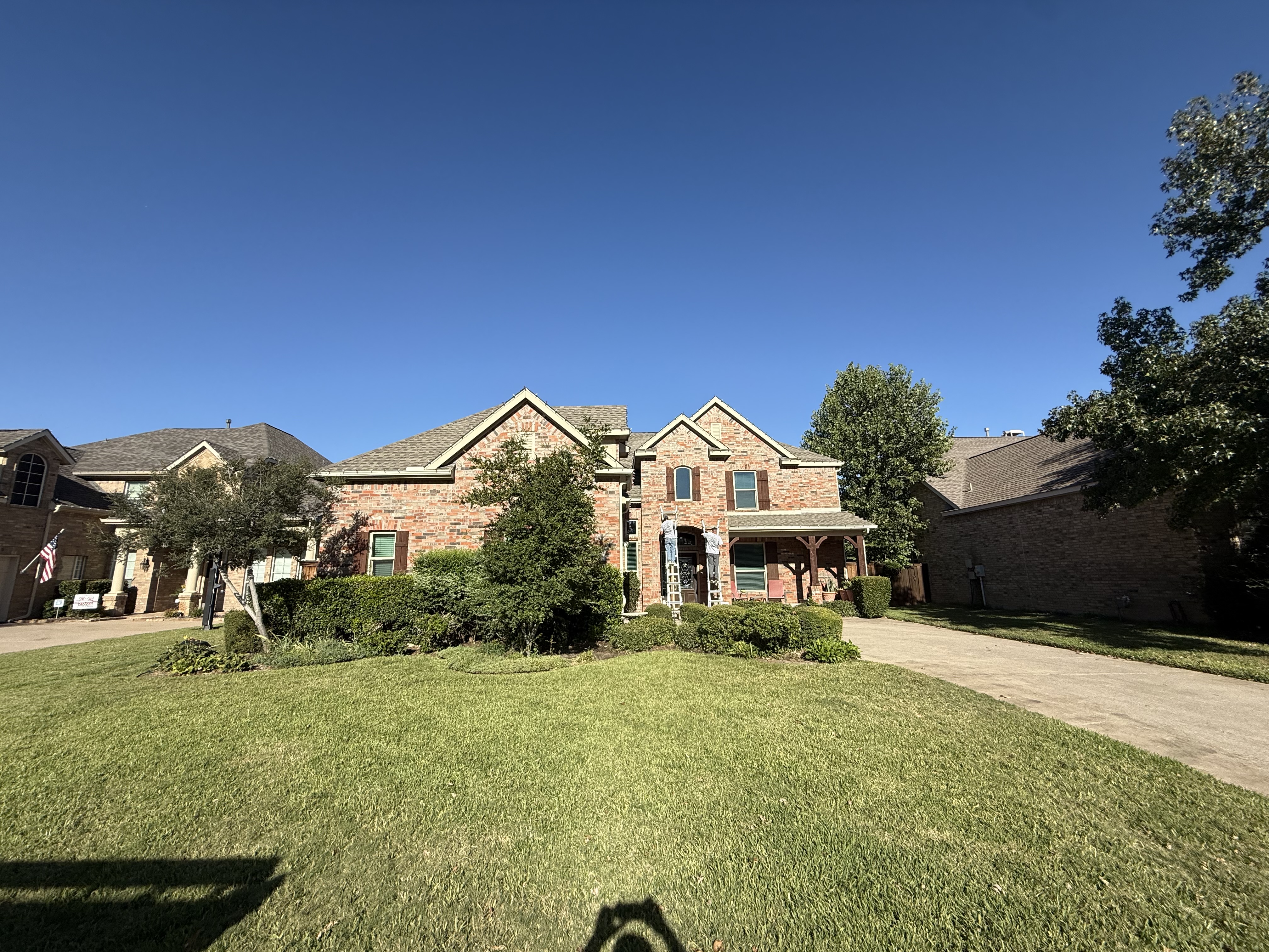 Two-story brick home with beautiful landscaping ready for lighting