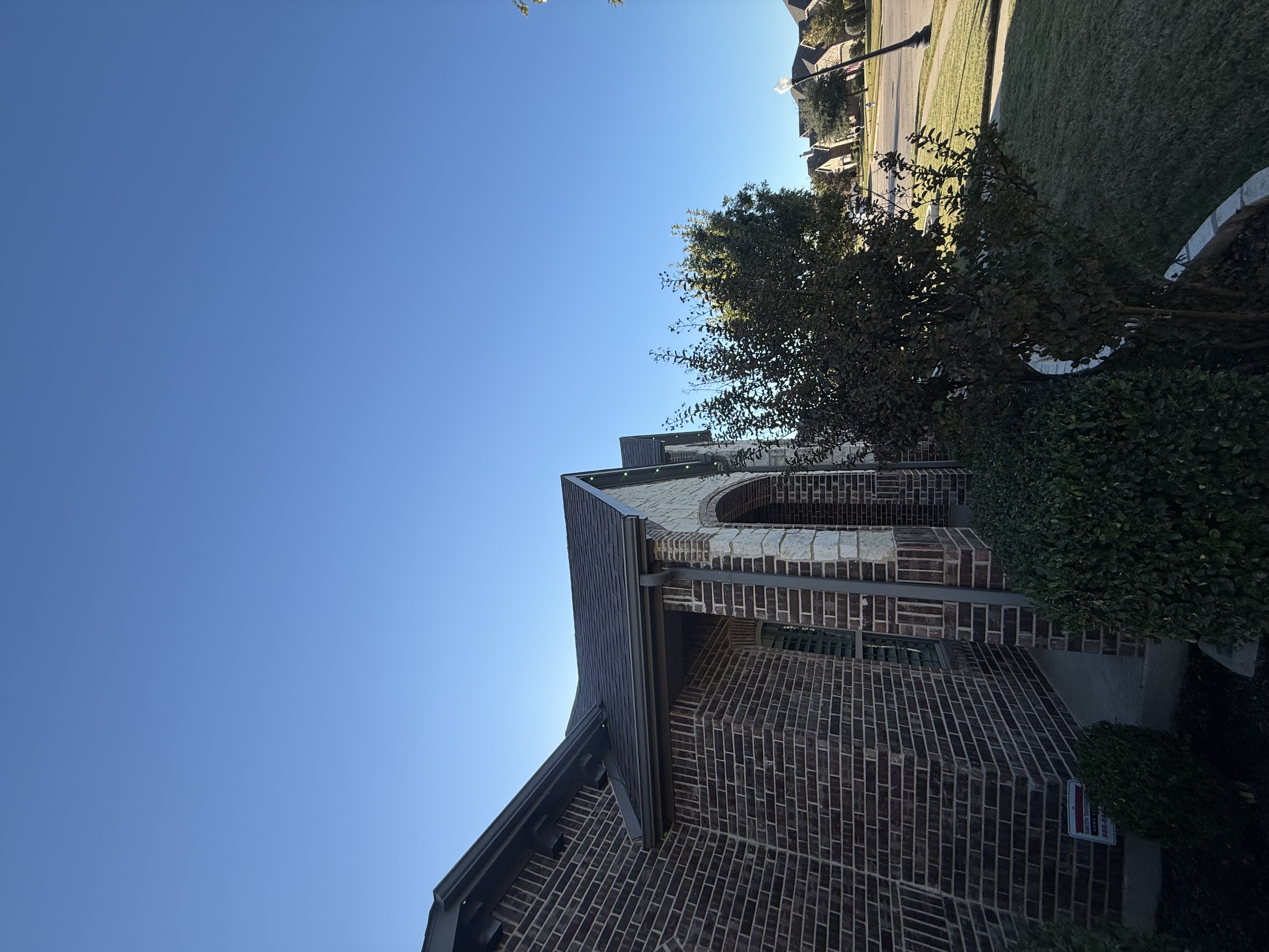 Professional permanent lighting installation on brick home roofline