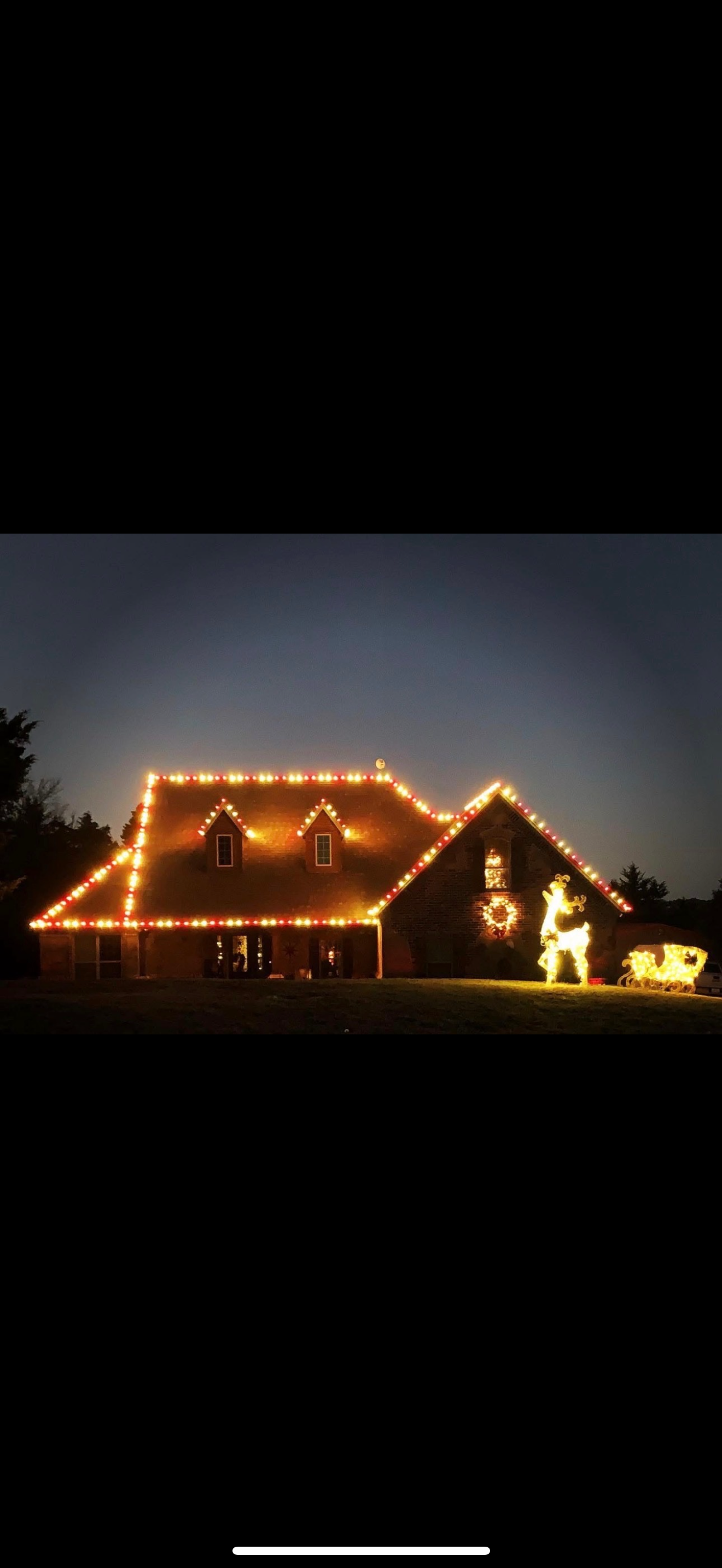 Beautiful holiday light display on home at night with decorative figures